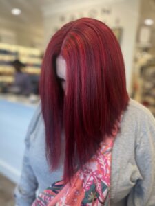 A woman with maroon hairs after professionals have worked on them